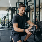 Osoba ćwicząca na siłowni zwiększa obciążenie ostrożnie i z kontrolą techniki