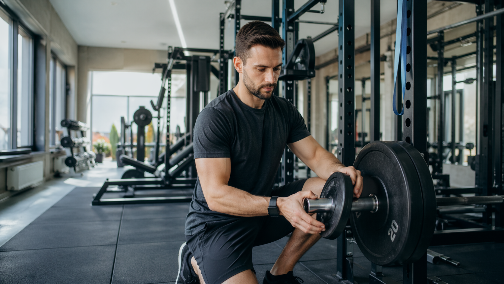 Osoba ćwicząca na siłowni zwiększa obciążenie ostrożnie i z kontrolą techniki