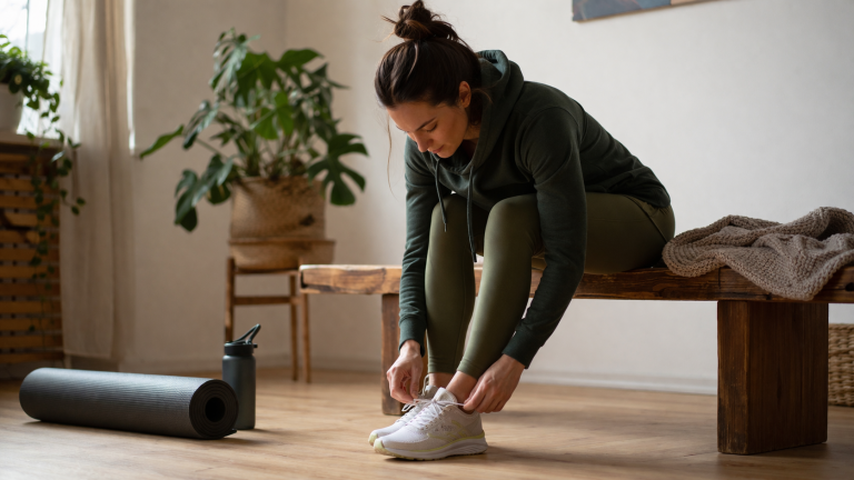 Osoba wiąże buty sportowe przed krótkim treningiem